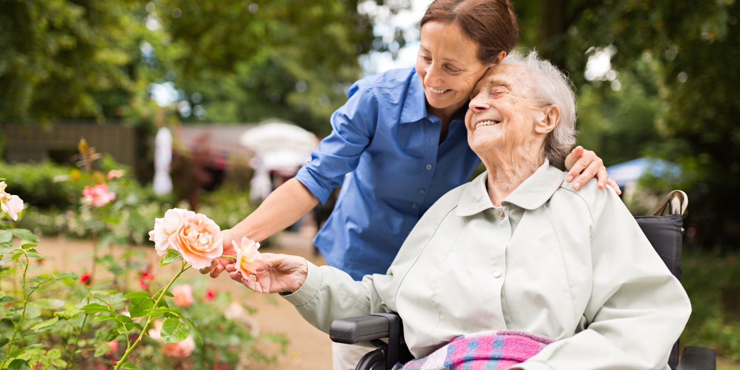 Senior woman with caregiver in the garden
